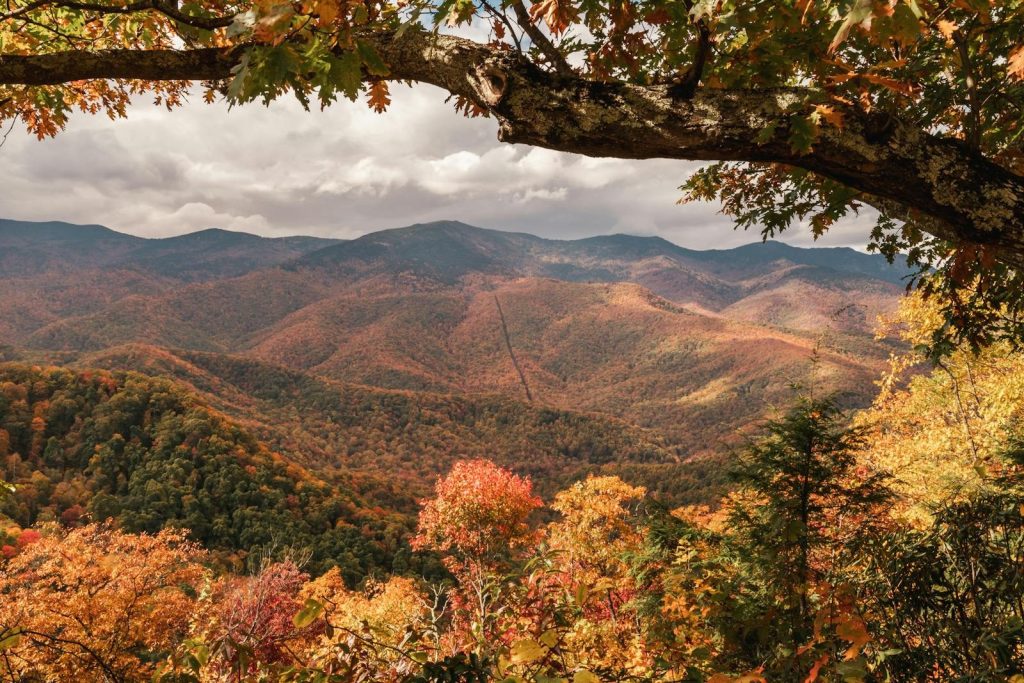 Captivating view of Smoky Mountains with vibrant fall foliage and dramatic skies.