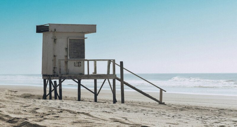 best beaches in Argentina white wooden lifeguard house on beach shore during daytime