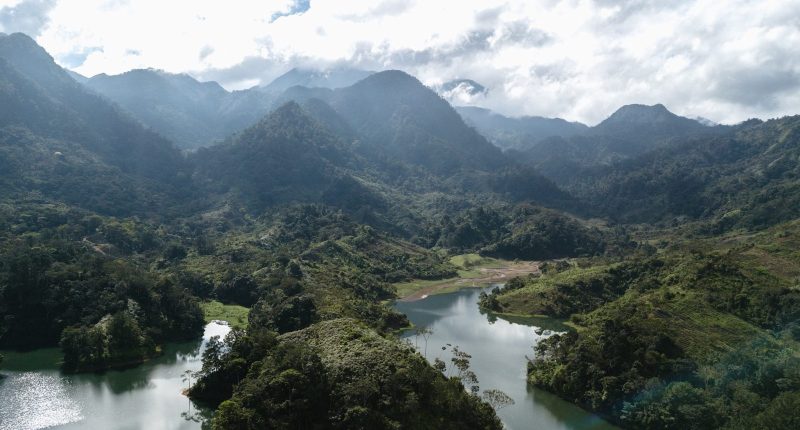 honduras travel guide green mountains and river under white clouds during daytime