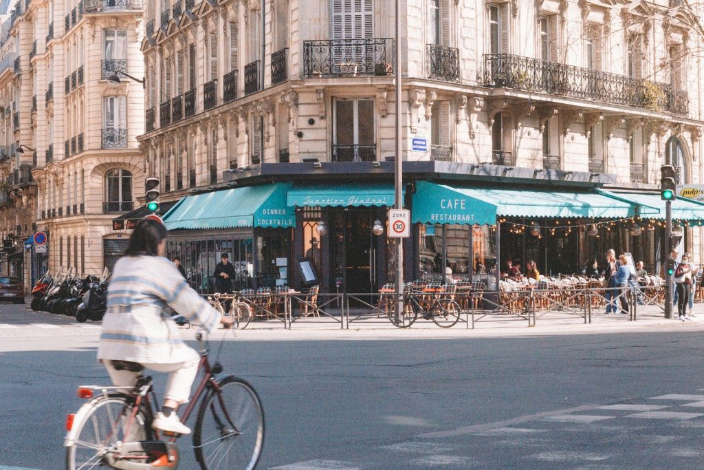 a man riding a bike down a street next to tall buildings